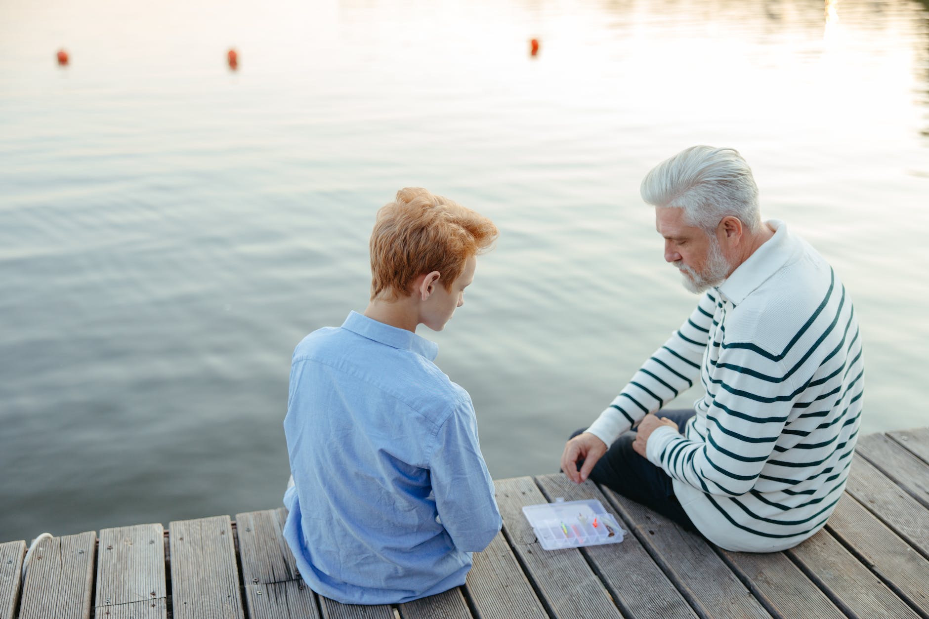 a grandfather teaching a boy about fishing baits